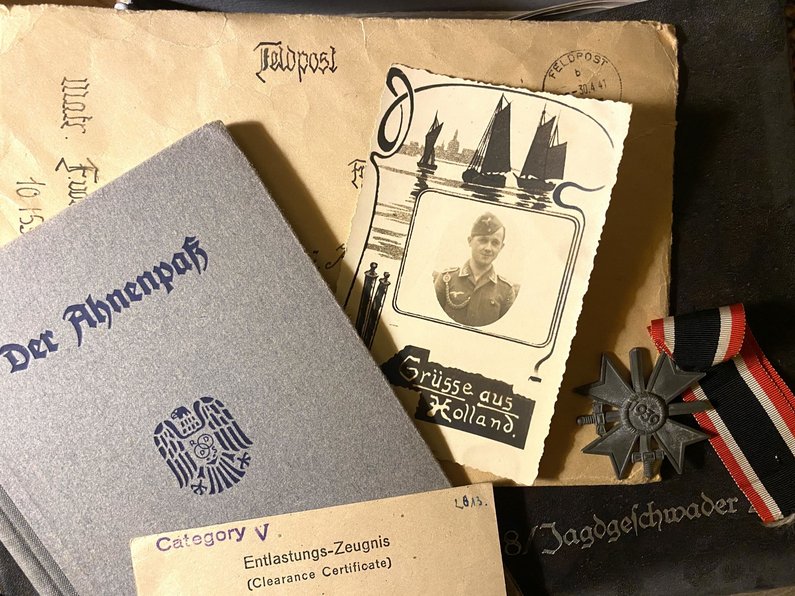 Das Foto zeigt Dokumente aus der NS-Zeit: einen Ahnenpass, ein Foto und Feldpost.